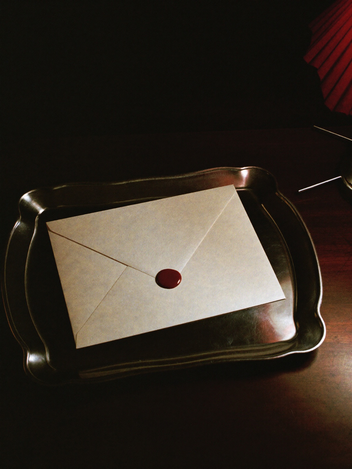 A sealed envelope on a silver tray: the handover